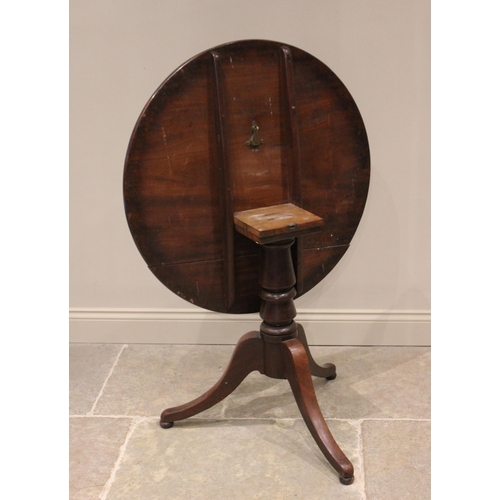 595 - A George III mahogany tripod table, the circular top raised upon a baluster pedestal extending to th... 