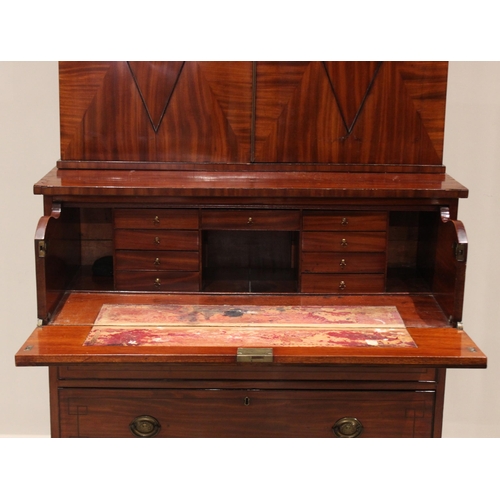 596 - A late George III mahogany secretaire bookcase, the moulded cornice over a pair of segmentally venee... 