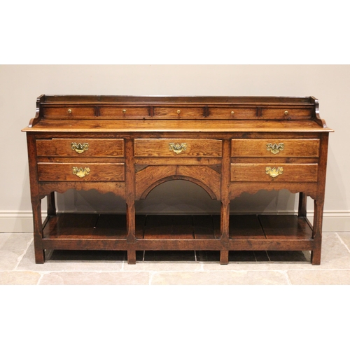 604 - A George III oak high back pot board dresser, the moulded cornice above a scalloped frieze and three... 