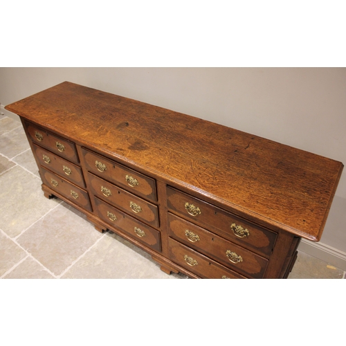 612 - A George III oak and mahogany crossbanded dresser base, the rectangular moulded plank top above an a... 