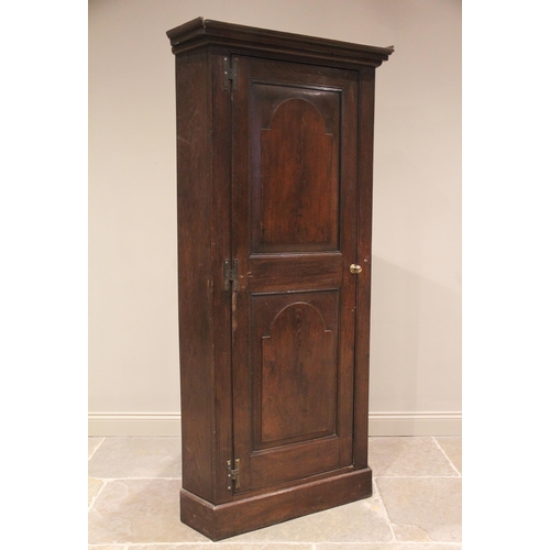 614 - A George III oak freestanding corner cupboard, the single full length door with two fielded panels o... 