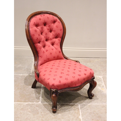 632 - A Victorian mahogany framed balloon back nursing chair, later re-covered in red foliate fabric, the ... 