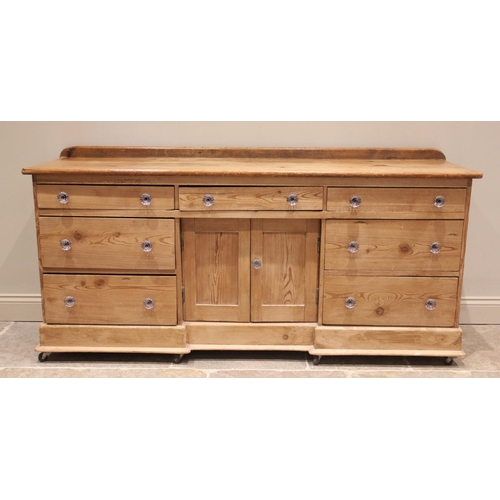 658 - A Victorian pine dresser base, the rectangular top above an arrangement of seven drawers and a pair ... 