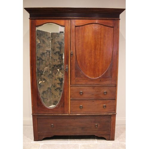 661 - An Edwardian mahogany compactum wardrobe, formed with a shield shaped panelled cupboard door, over t... 