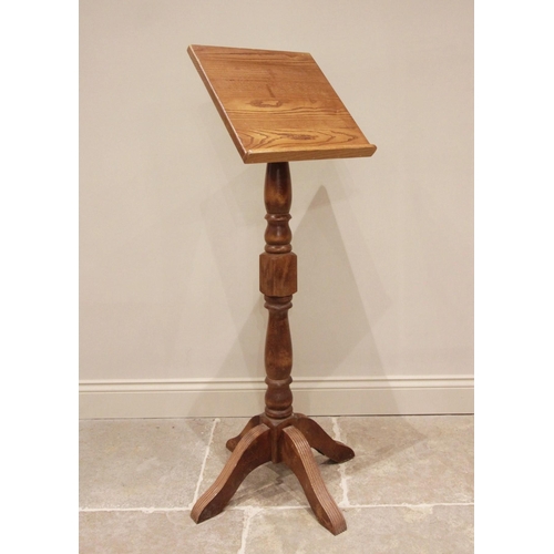 672 - An oak and beech wood lectern, late 20th century, the sloping book rest raised upon a block and balu... 