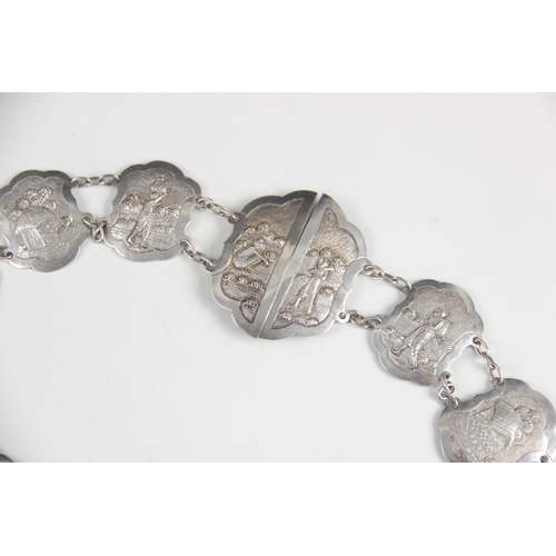 25 - An Asian silver coloured belt, each lozenge shaped link with scalloped borders, embossed with rural ... 