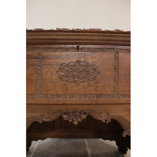 639 - An Anglo-Indian teak scholars table, the foliate relief carved hinged cover opening to reveal an arr... 