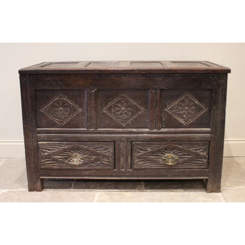 591 - An 18th century carved oak mule chest, the four panel hinged top over three front panels and two dra... 