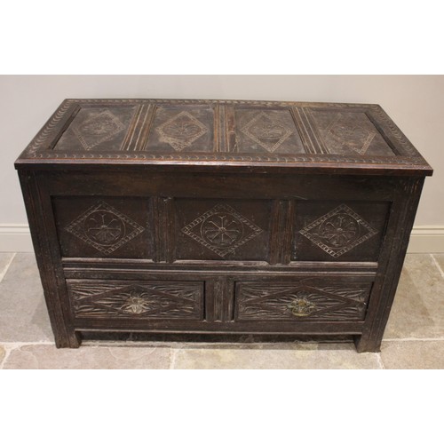 591 - An 18th century carved oak mule chest, the four panel hinged top over three front panels and two dra... 