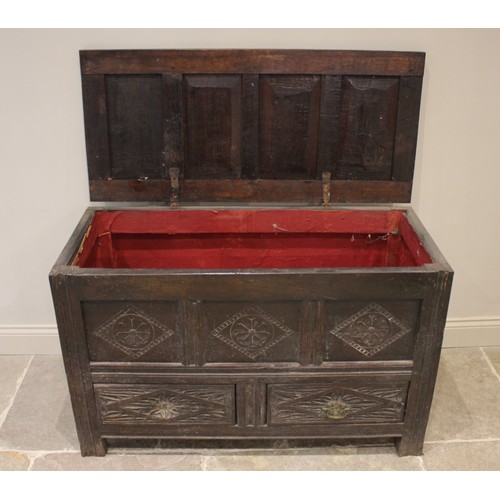 591 - An 18th century carved oak mule chest, the four panel hinged top over three front panels and two dra... 