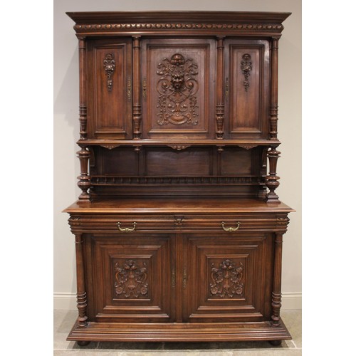 650 - A late 19th/early 20th century French walnut side cabinet, the upper section with three carved doors... 