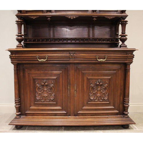 650 - A late 19th/early 20th century French walnut side cabinet, the upper section with three carved doors... 