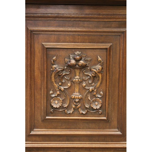 650 - A late 19th/early 20th century French walnut side cabinet, the upper section with three carved doors... 