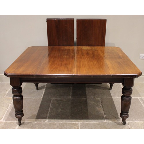 664 - An Edwardian walnut extending dining table, the rectangular top with canted corners, raised upon ree... 