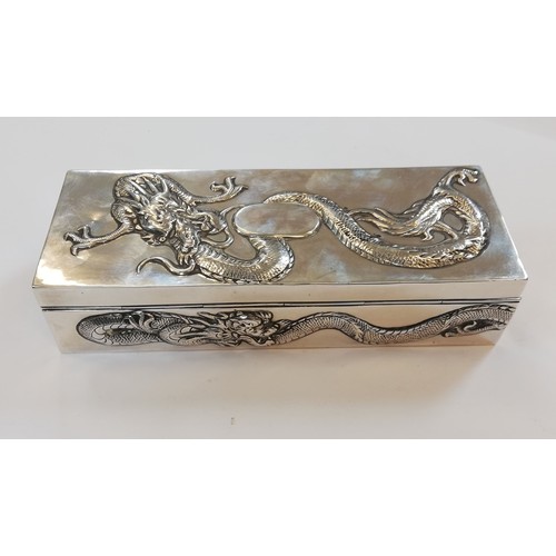 5 - A Chinese silver trinket box, possibly Po Cheng, of rectangular form, chased in relief with dragons,... 