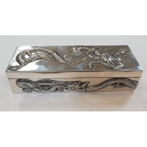 5 - A Chinese silver trinket box, possibly Po Cheng, of rectangular form, chased in relief with dragons,... 