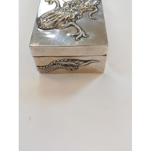 5 - A Chinese silver trinket box, possibly Po Cheng, of rectangular form, chased in relief with dragons,... 
