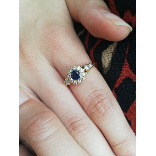 117 - An early 20th century sapphire and diamond floral cluster ring, the central round mixed cut sapphire... 