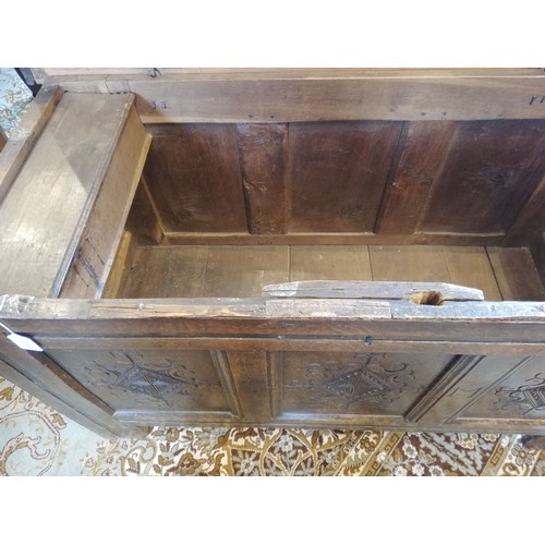 587 - An early 18th century oak coffer, the three plank top opening to a fitted candle box, above the thre... 