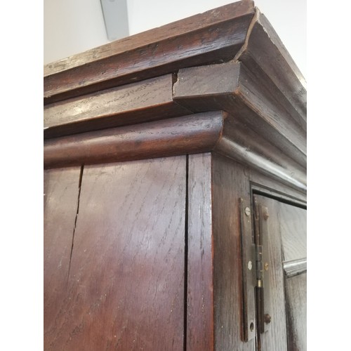 614 - A George III oak freestanding corner cupboard, the single full length door with two fielded panels o... 