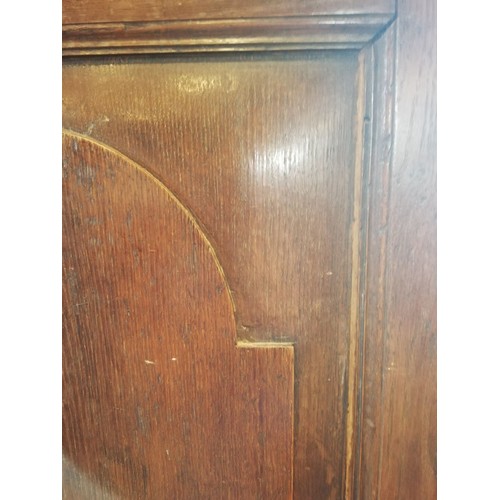 614 - A George III oak freestanding corner cupboard, the single full length door with two fielded panels o... 