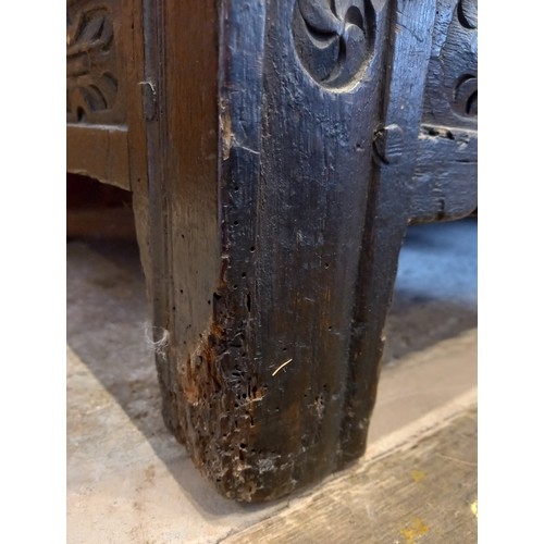 584 - A late 17th century/early 18th century carved oak coffer, the three panel cover opening to a fitted ... 