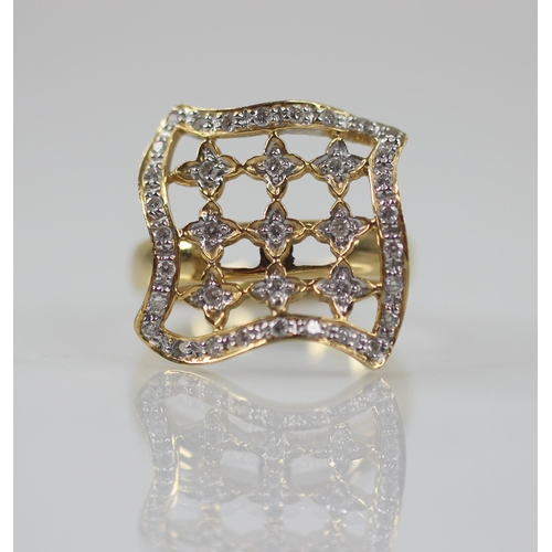 102 - A diamond set swivel head ring, the shaped square head with pierced detail set with round mixed cut ... 