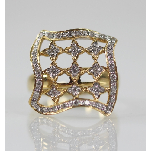 102 - A diamond set swivel head ring, the shaped square head with pierced detail set with round mixed cut ... 