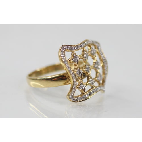 102 - A diamond set swivel head ring, the shaped square head with pierced detail set with round mixed cut ... 