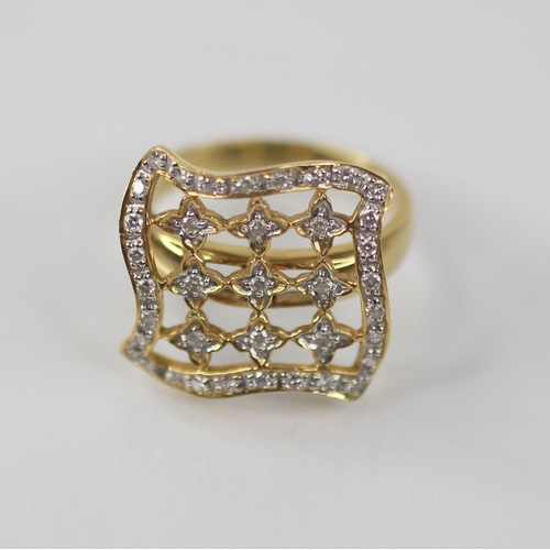 102 - A diamond set swivel head ring, the shaped square head with pierced detail set with round mixed cut ... 