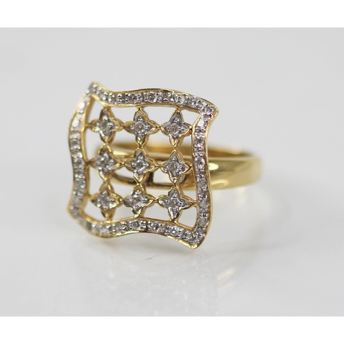 102 - A diamond set swivel head ring, the shaped square head with pierced detail set with round mixed cut ... 