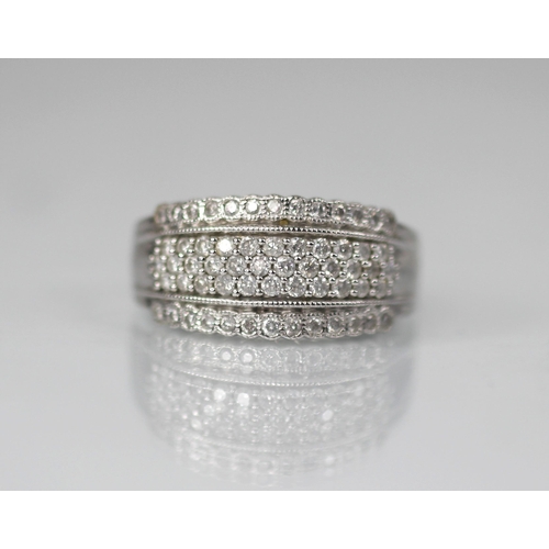 103 - A diamond set 18ct white gold ring, the raised central channel pave set with three rows of round mix... 