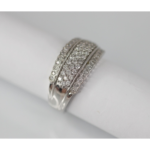 103 - A diamond set 18ct white gold ring, the raised central channel pave set with three rows of round mix... 