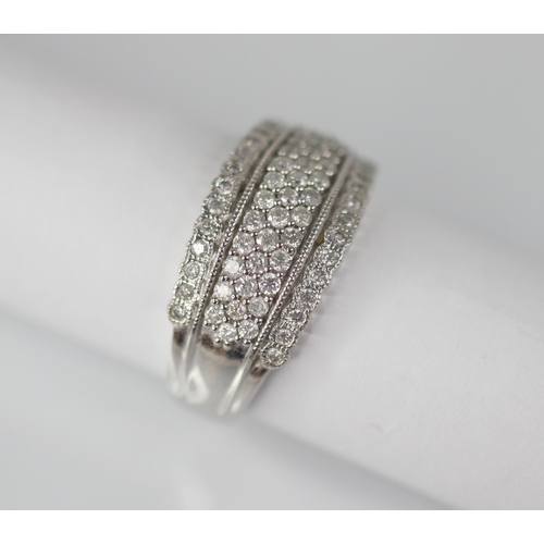 103 - A diamond set 18ct white gold ring, the raised central channel pave set with three rows of round mix... 