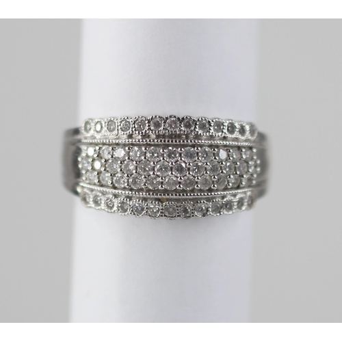 103 - A diamond set 18ct white gold ring, the raised central channel pave set with three rows of round mix... 