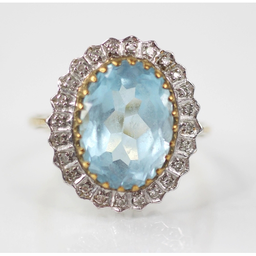 119 - A blue topaz and diamond 9ct gold cluster ring, the oval mixed cut topaz measuring 14mm x 9mm, set t... 