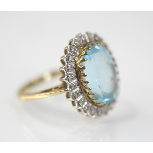 119 - A blue topaz and diamond 9ct gold cluster ring, the oval mixed cut topaz measuring 14mm x 9mm, set t... 