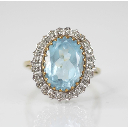 119 - A blue topaz and diamond 9ct gold cluster ring, the oval mixed cut topaz measuring 14mm x 9mm, set t... 