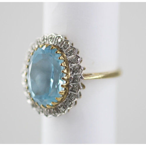 119 - A blue topaz and diamond 9ct gold cluster ring, the oval mixed cut topaz measuring 14mm x 9mm, set t... 