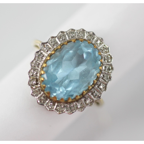 119 - A blue topaz and diamond 9ct gold cluster ring, the oval mixed cut topaz measuring 14mm x 9mm, set t... 