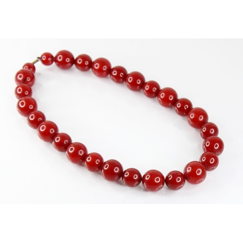 120 - A cherry amber bead necklace, comprising twenty-seven spherical cherry amber beads, smallest 13.5mm ... 