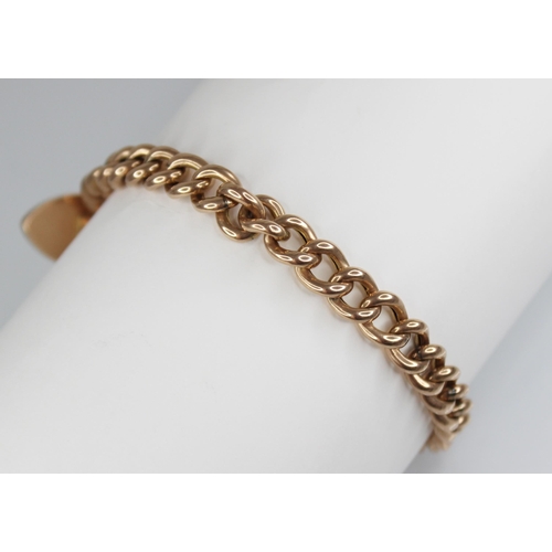 123 - A Victorian gold coloured curb link bracelet, jump-links stamped '9CT', approximately 18cm long, sus... 