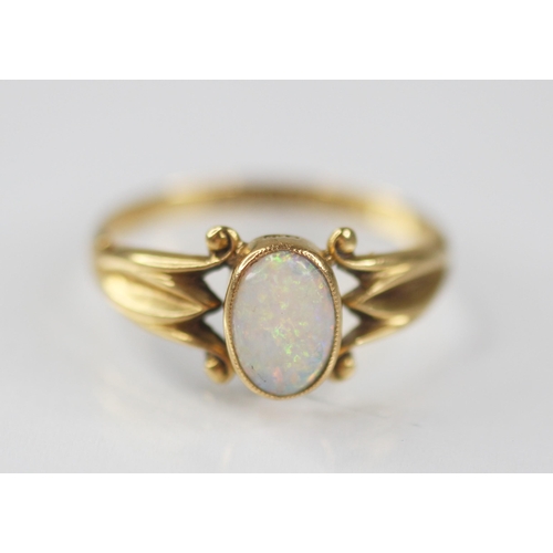 125 - An early 20th century opal 18ct gold ring, the central oval opal cabochon measuring 7.5mm x 5mm, bez... 