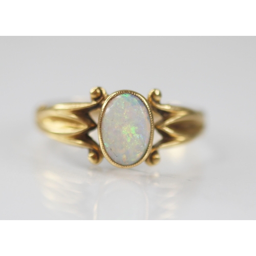 125 - An early 20th century opal 18ct gold ring, the central oval opal cabochon measuring 7.5mm x 5mm, bez... 