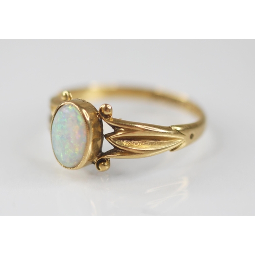 125 - An early 20th century opal 18ct gold ring, the central oval opal cabochon measuring 7.5mm x 5mm, bez... 