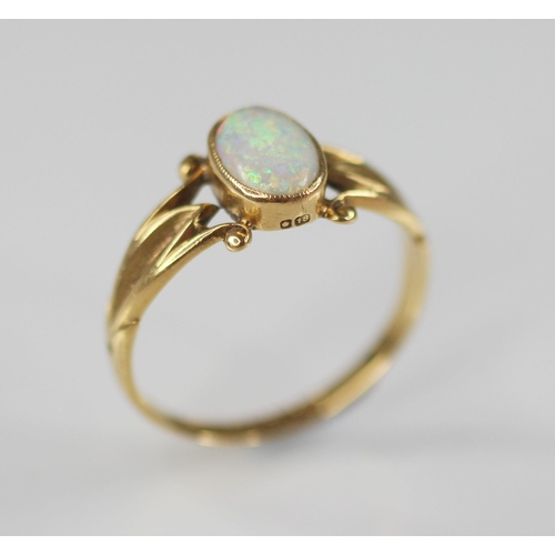 125 - An early 20th century opal 18ct gold ring, the central oval opal cabochon measuring 7.5mm x 5mm, bez... 