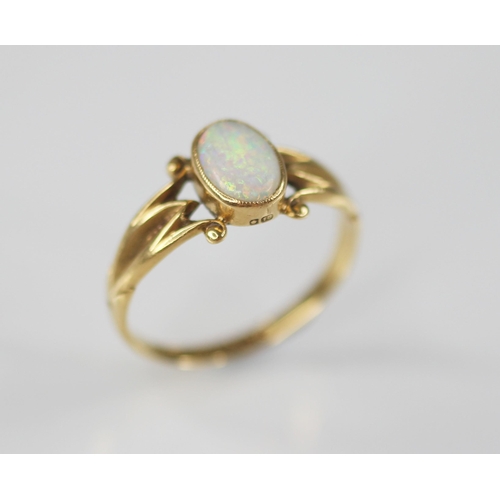 125 - An early 20th century opal 18ct gold ring, the central oval opal cabochon measuring 7.5mm x 5mm, bez... 