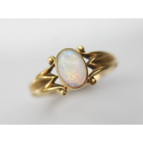 125 - An early 20th century opal 18ct gold ring, the central oval opal cabochon measuring 7.5mm x 5mm, bez... 