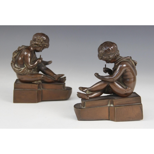 157 - A pair of French bronze bookends, early 20th century, each modelled as a scribing cherub, each 11.5c... 