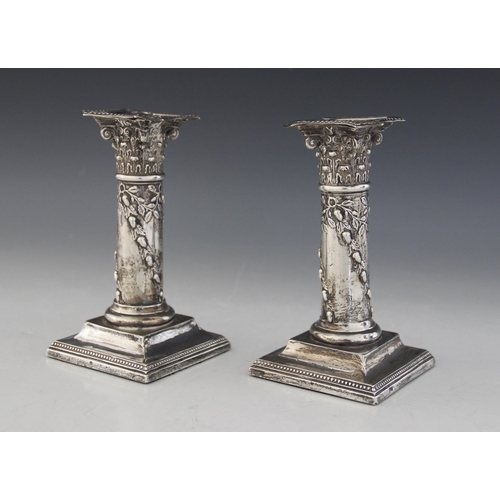 22 - A pair of early 20th century silver mounted candlesticks by Henry Matthews (date and assay marks wor... 